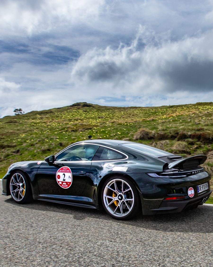 Porsche 911 GT3 vert foncé sur une route de montagne