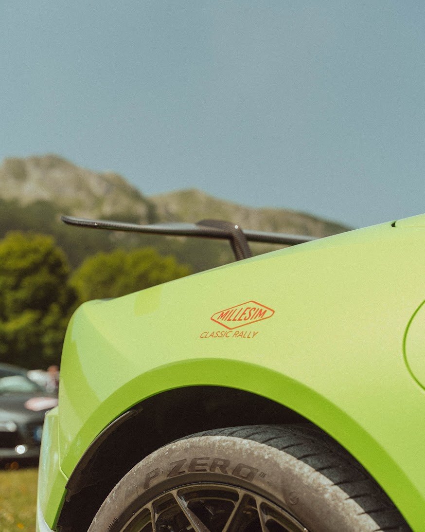 Aile verte d'une supercar avec le sticker rouge Millesim Classic Rally, au-dessus d'un pneu Pirelli P Zero